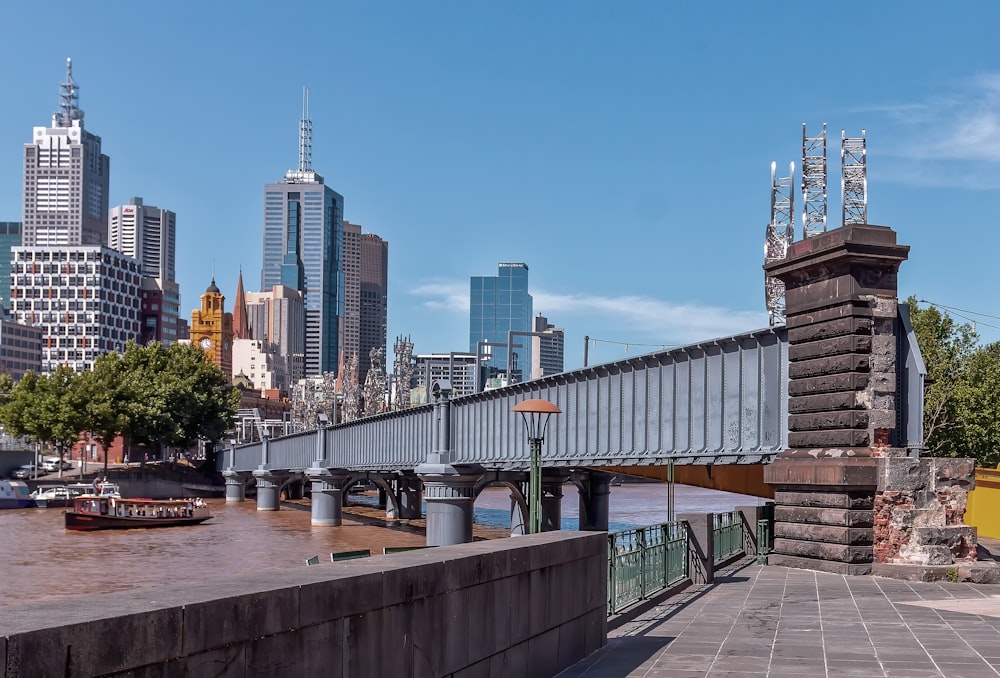 a bridge over a body of water with a city in the background