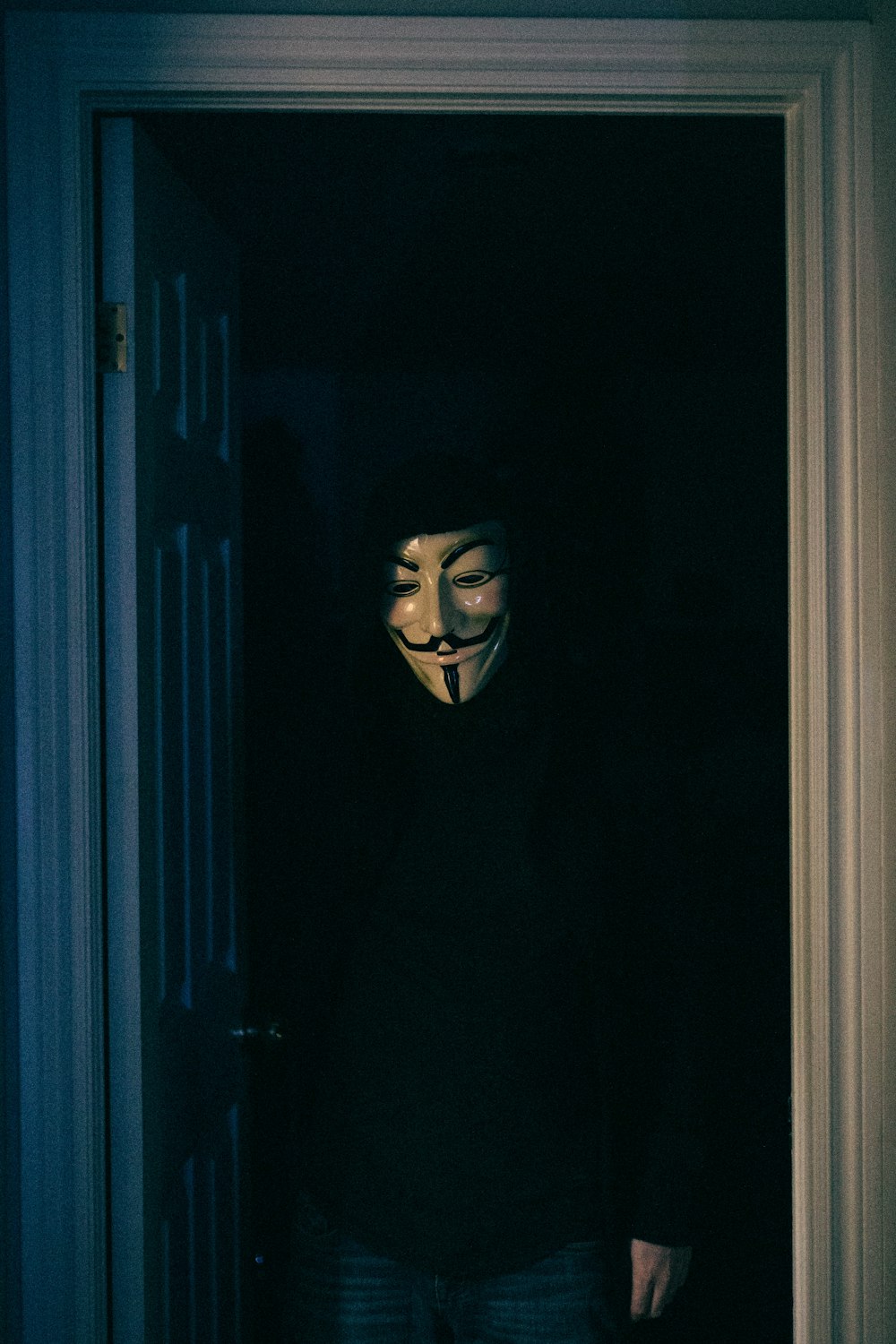 a person wearing a mask standing in a doorway