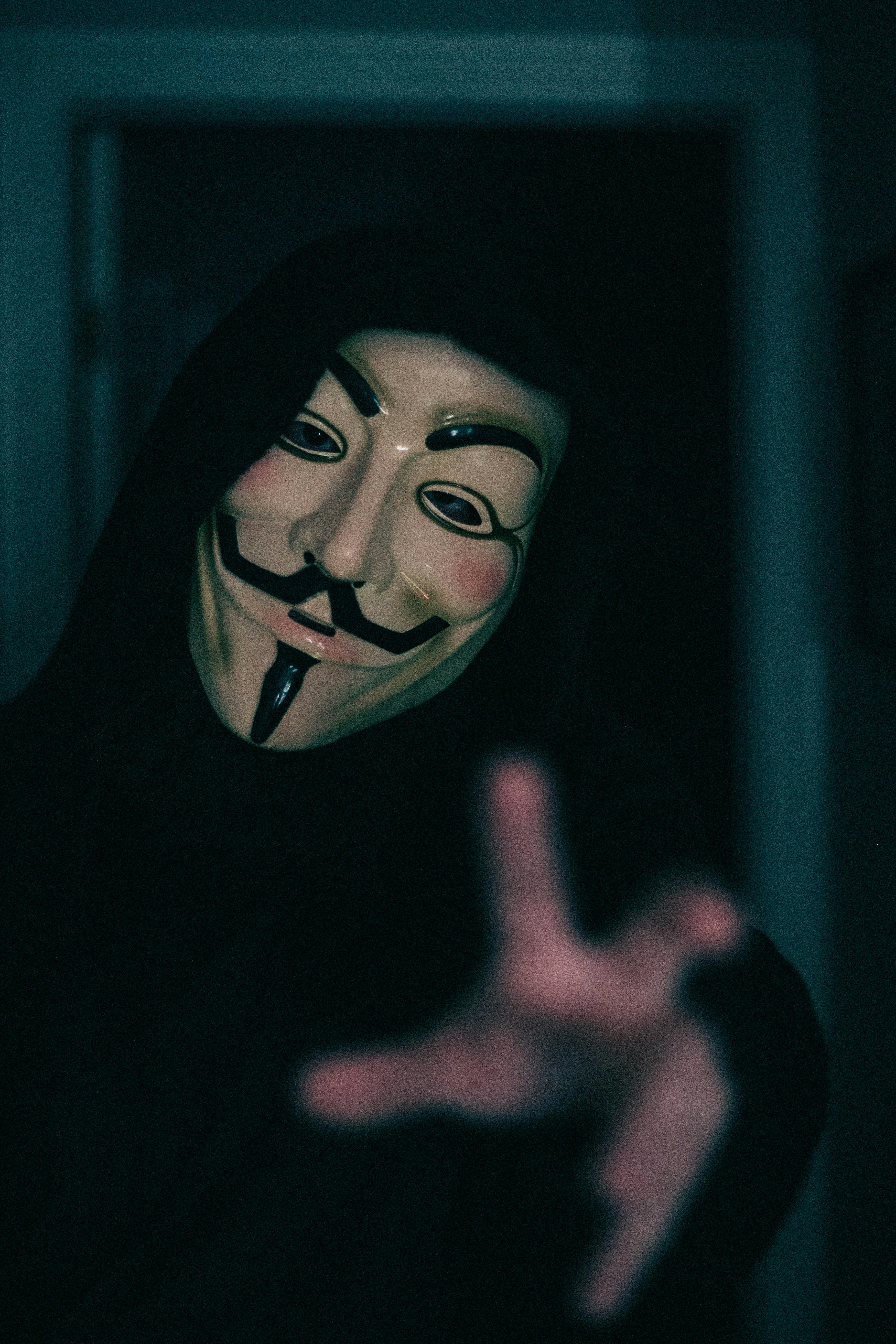 a person wearing a mask making a hand gesture