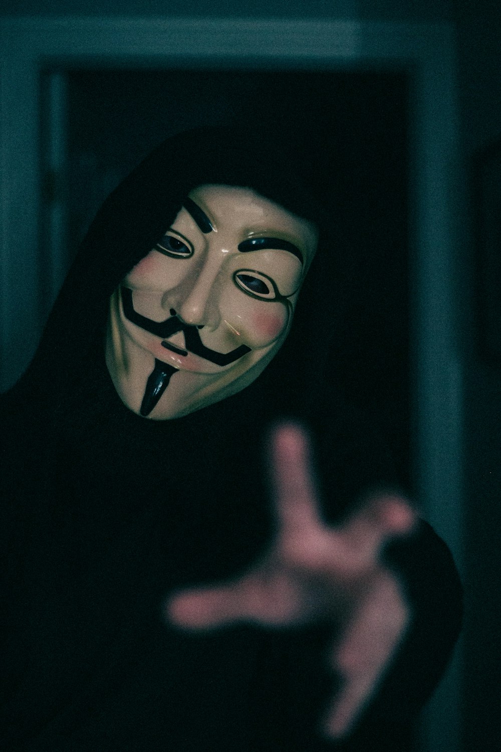 a person wearing a mask making a hand gesture