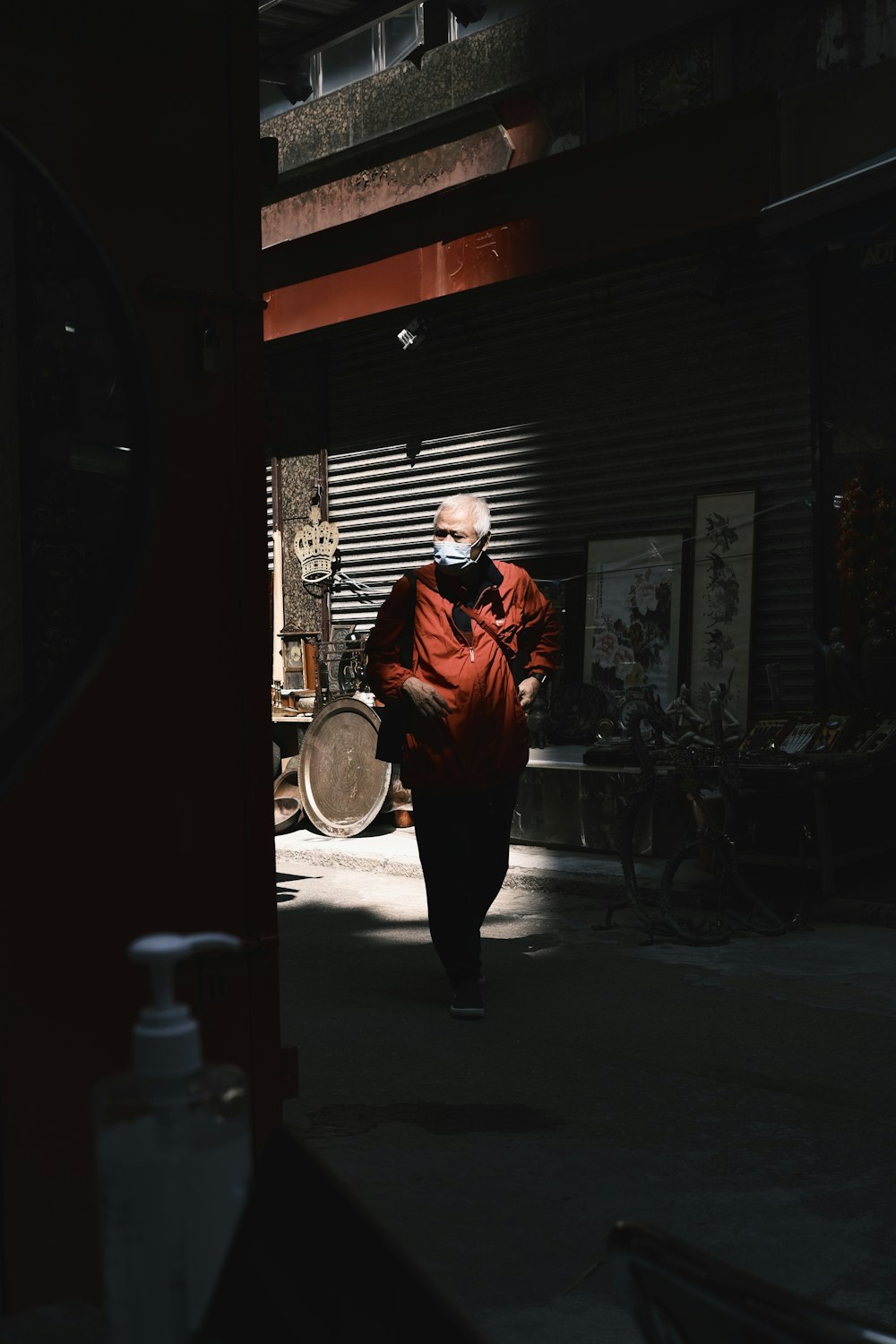 a man in a red jacket walking down a dark alley