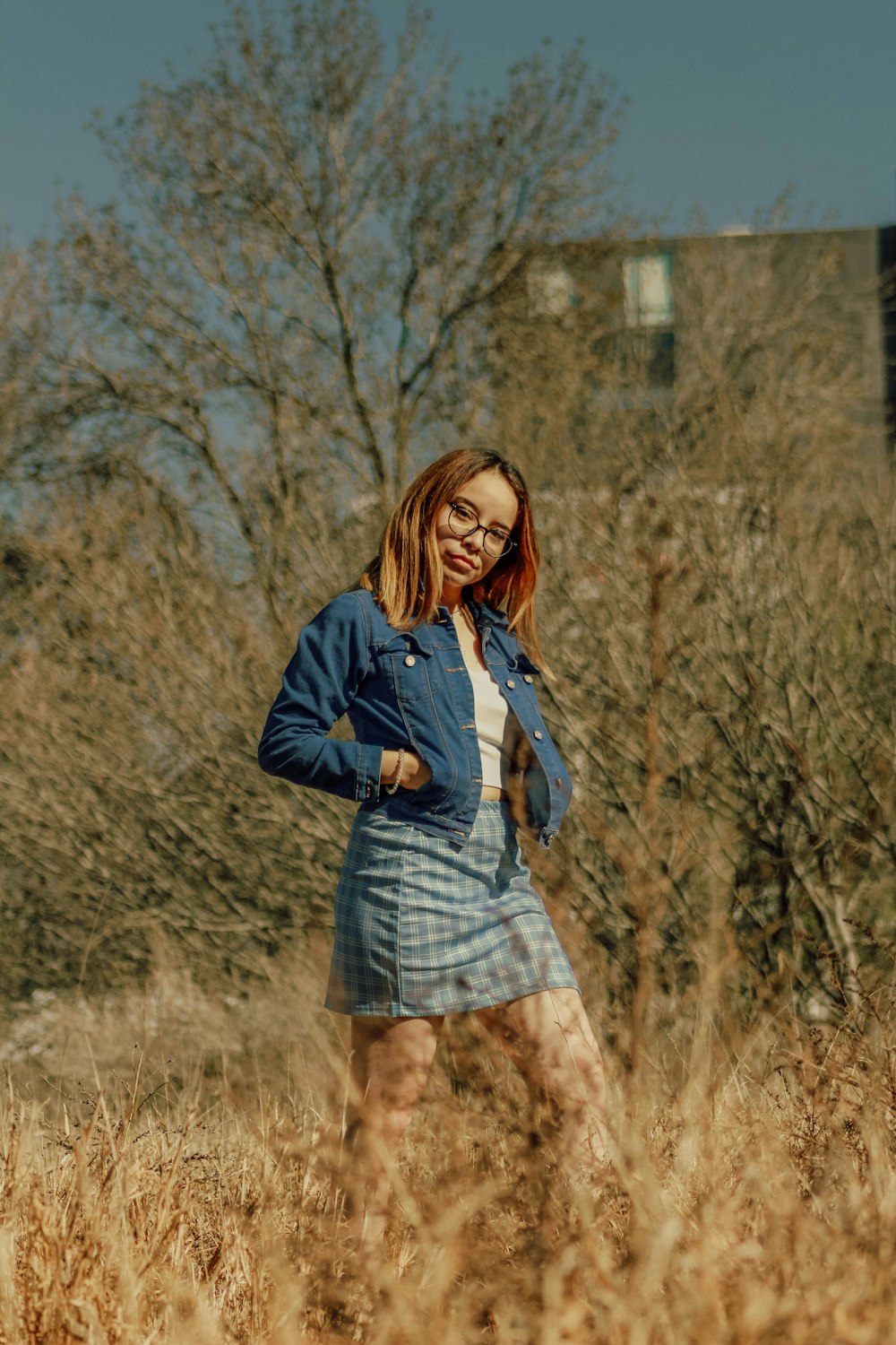 a woman standing in a field of tall grass