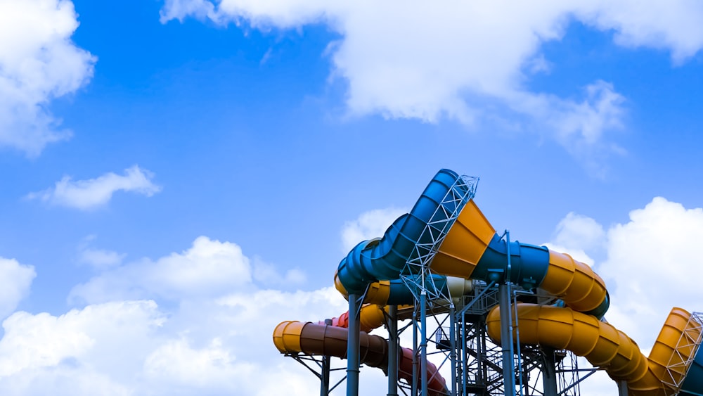 a blue and yellow water slide against a blue sky