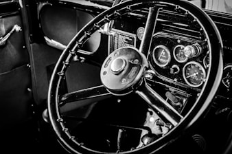 a black and white photo of a steering wheel and dashboard