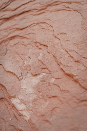 A close-up of textured layers creating depth and shadow in earthy tones.