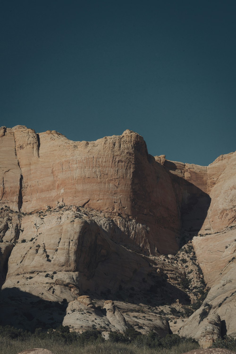 a large rock formation in the desert under a blue sky