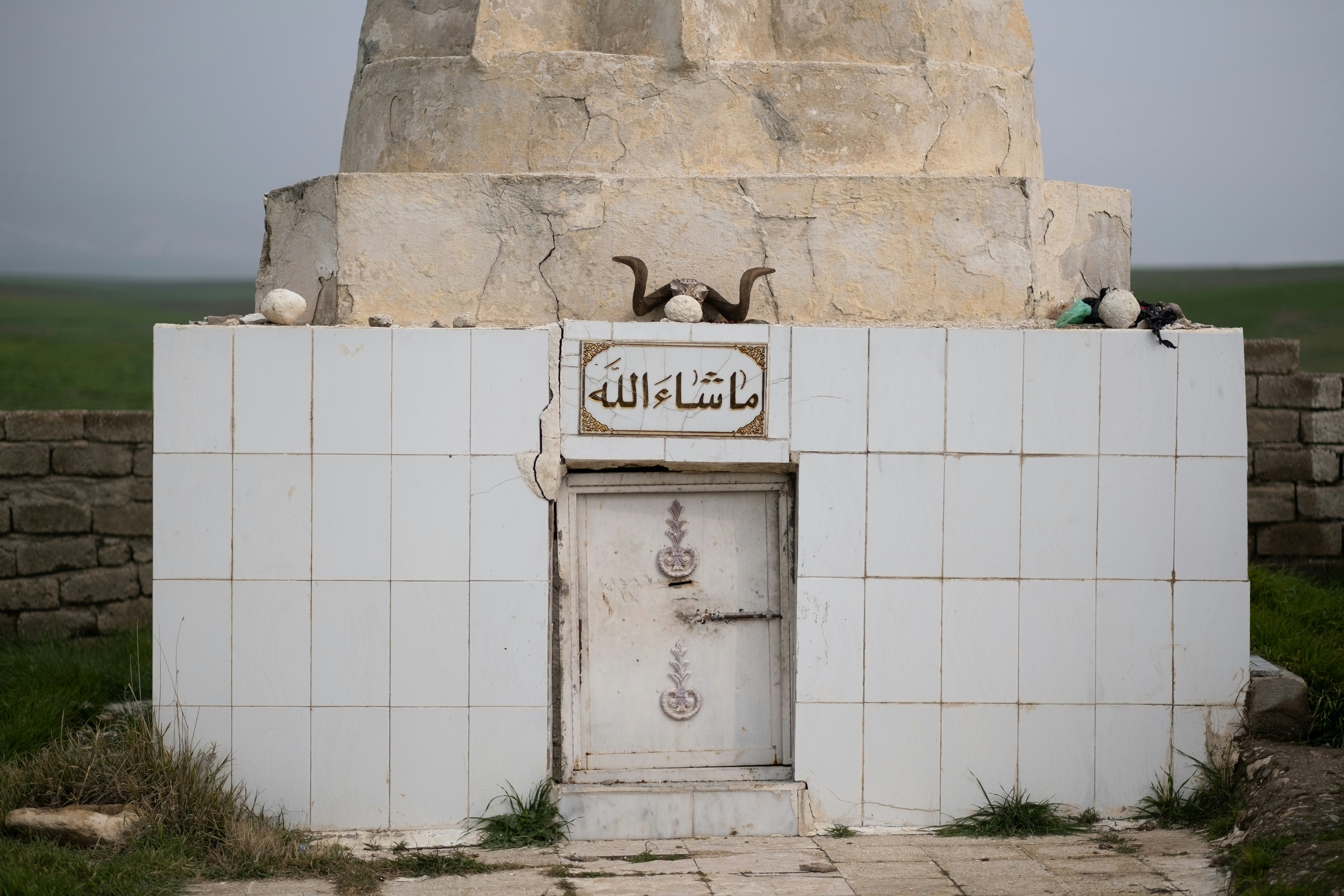 a white building with two rams on top of it