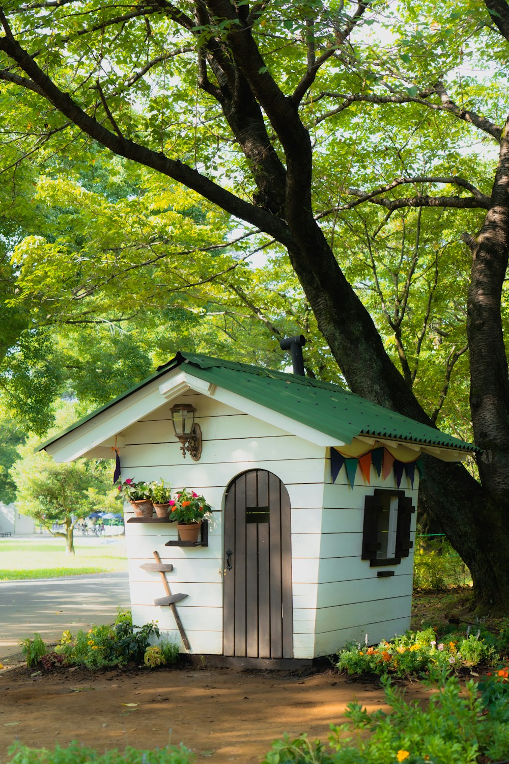 a small white shed with a green roof