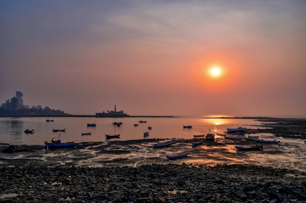 Sunset view over the calm sea with silhouettes of fishing boats returning to shore