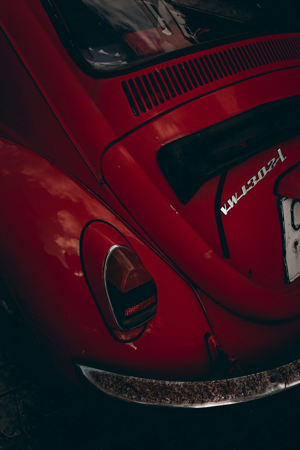 a red vw bug parked in a parking lot