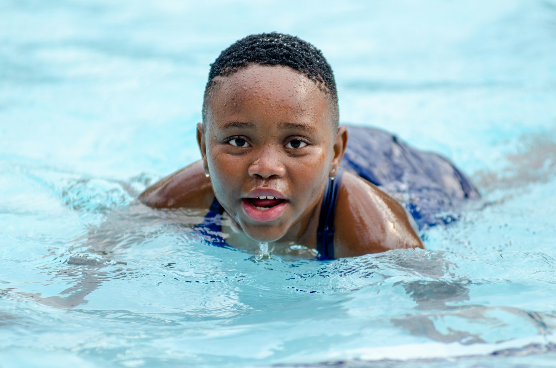 a young boy swimming in a pool of water