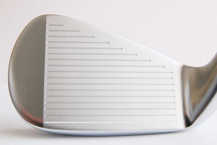 Close-up of a sleek Ping driver club head shining under natural light on a golf course