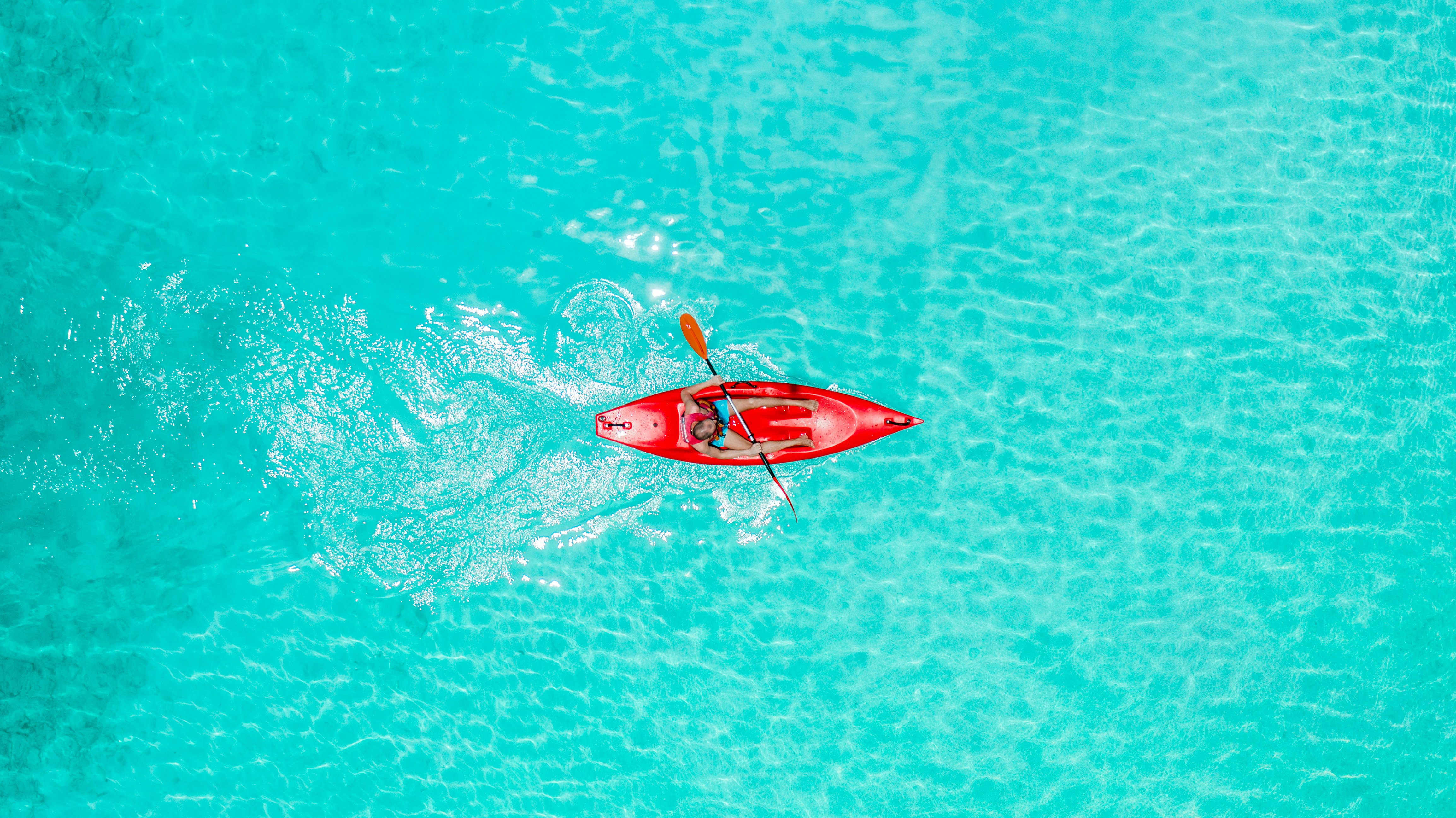 a person in a red kayak in the middle of the ocean