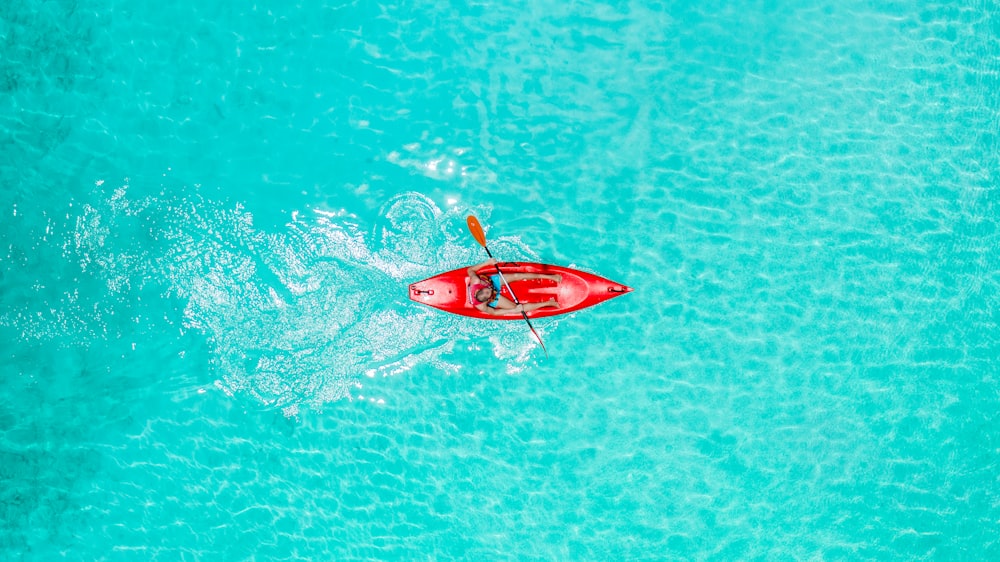 Une personne en kayak rouge au milieu de l’océan