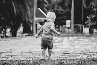 a little boy that is standing in the grass