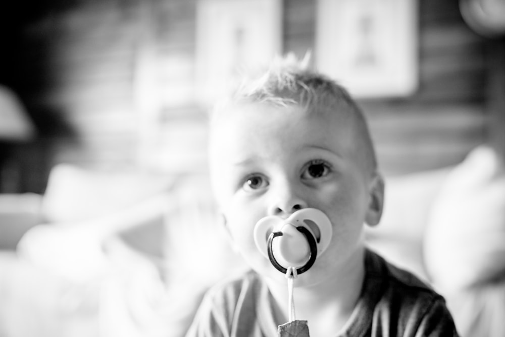 a little boy with a pacifier in his mouth