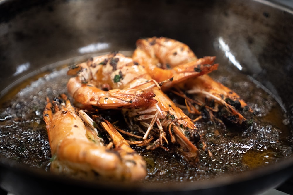 a frying pan filled with cooked shrimp