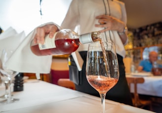 a person sitting at a table with wine glasses