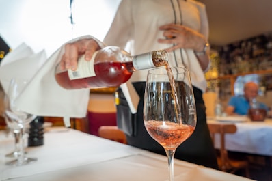 a person sitting at a table with wine glasses