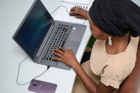 a woman sitting at a desk using a laptop computer