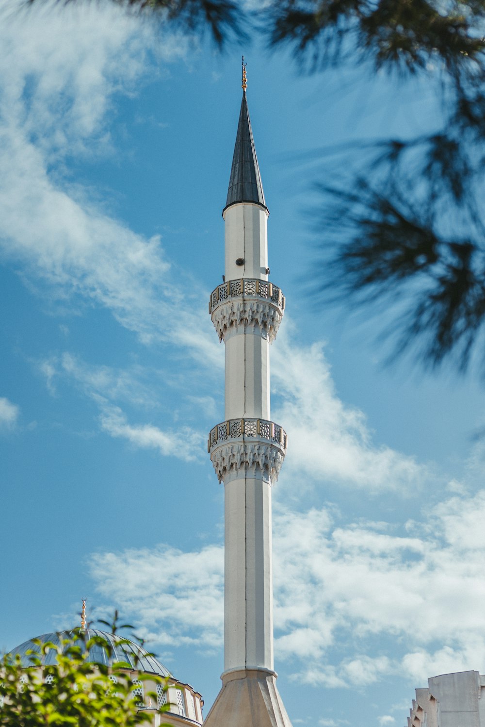 a tall white tower with a clock on it's side