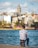 a man is sitting on a post by the water