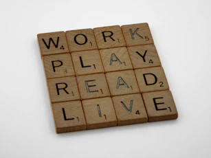a scrabble tile with words that read work play read live