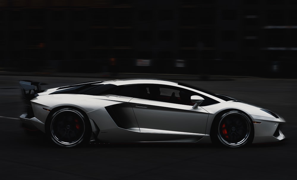 a white sports car driving down a street