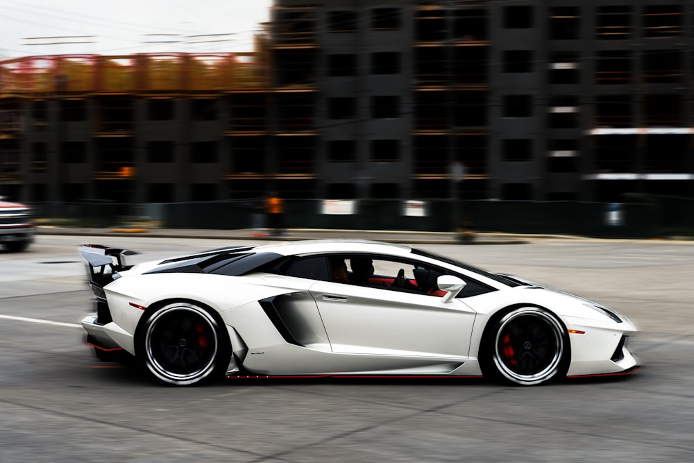 a white sports car driving down a street