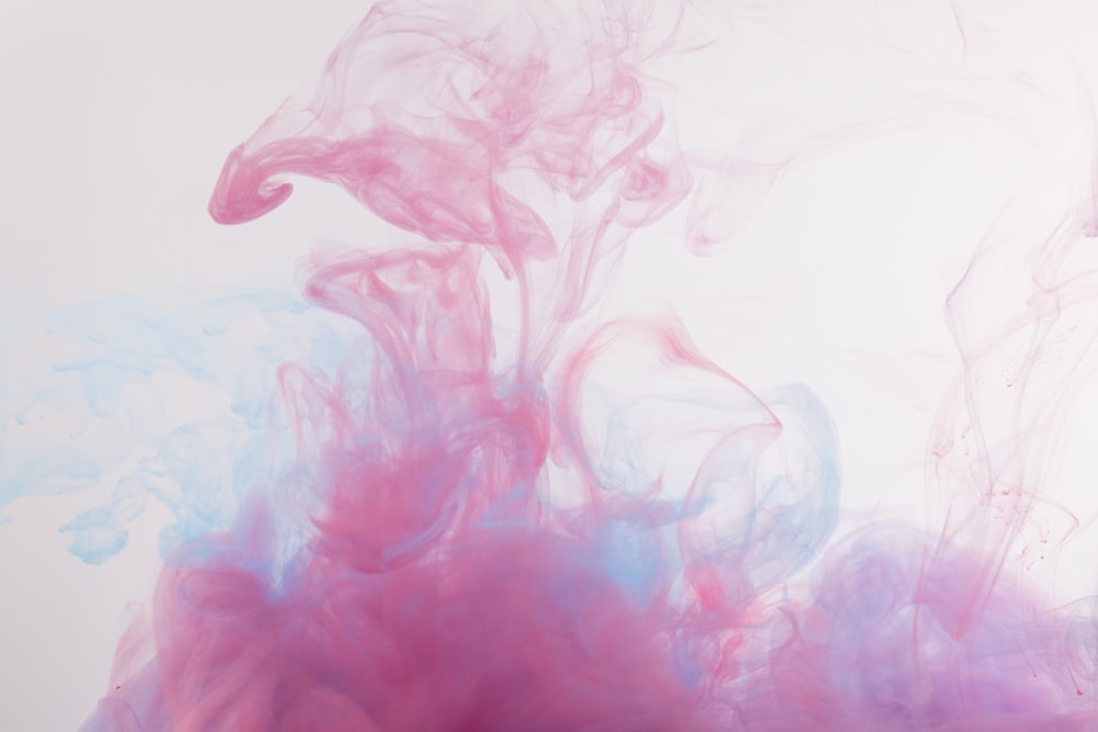 pink and blue ink in water on a white background