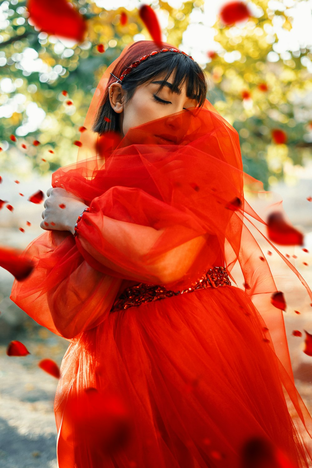 Una mujer con un vestido rojo con un velo en la cabeza