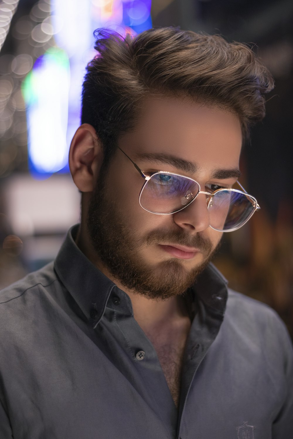 a man with a beard and glasses looking down