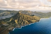 an aerial view of a mountain and the ocean