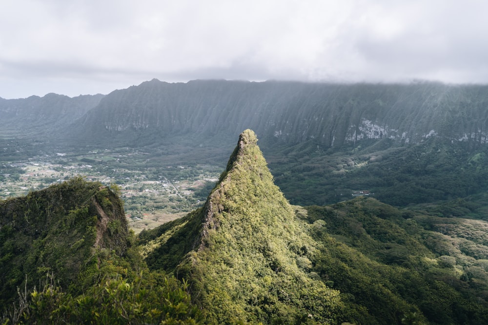 a view of a mountain with trees and mountains in the background