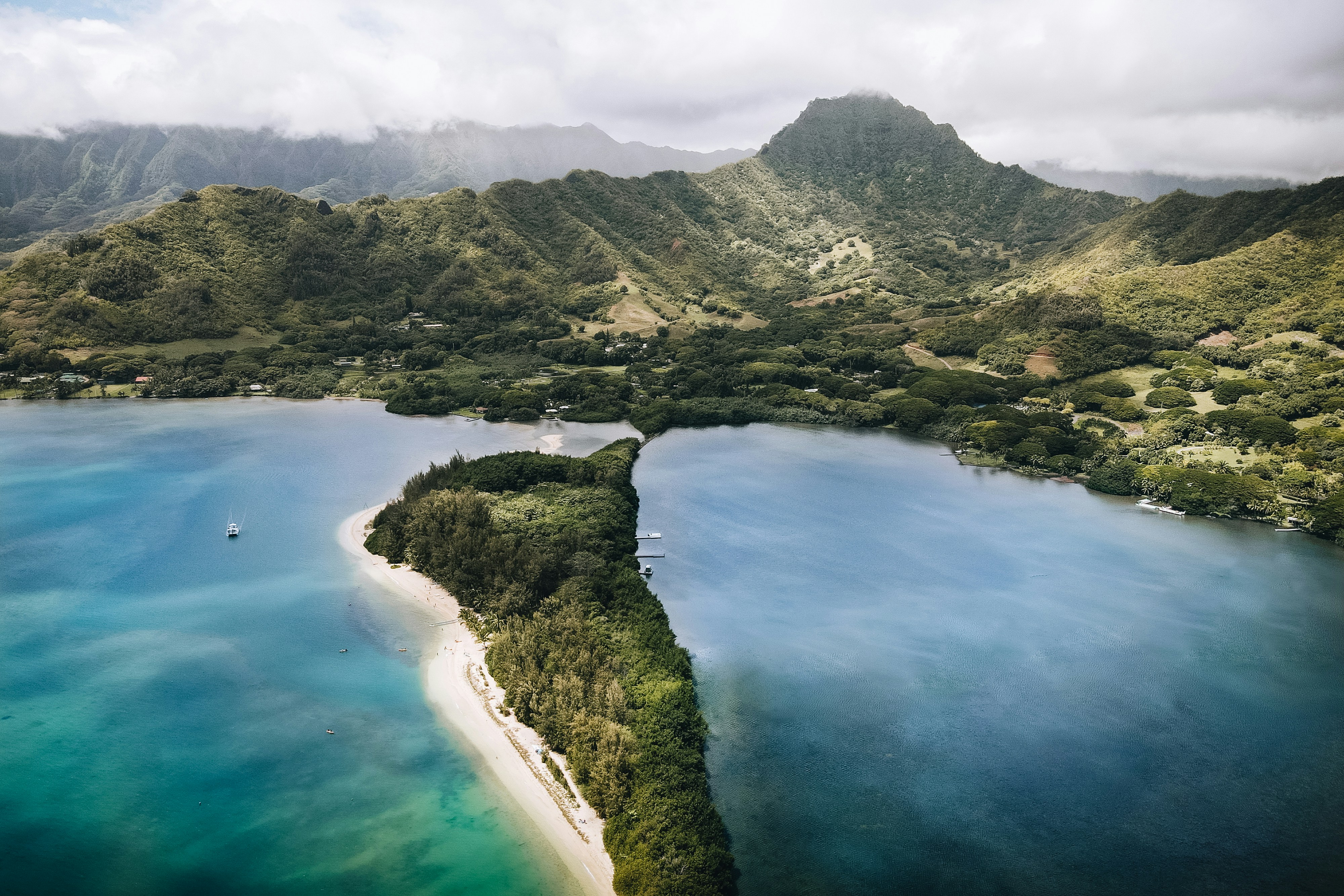 an aerial view of a tropical island surrounded by mountains