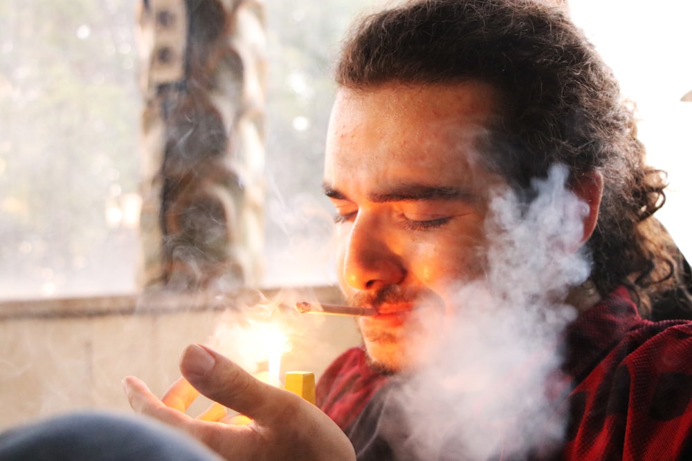 a man smoking a cigarette in a room