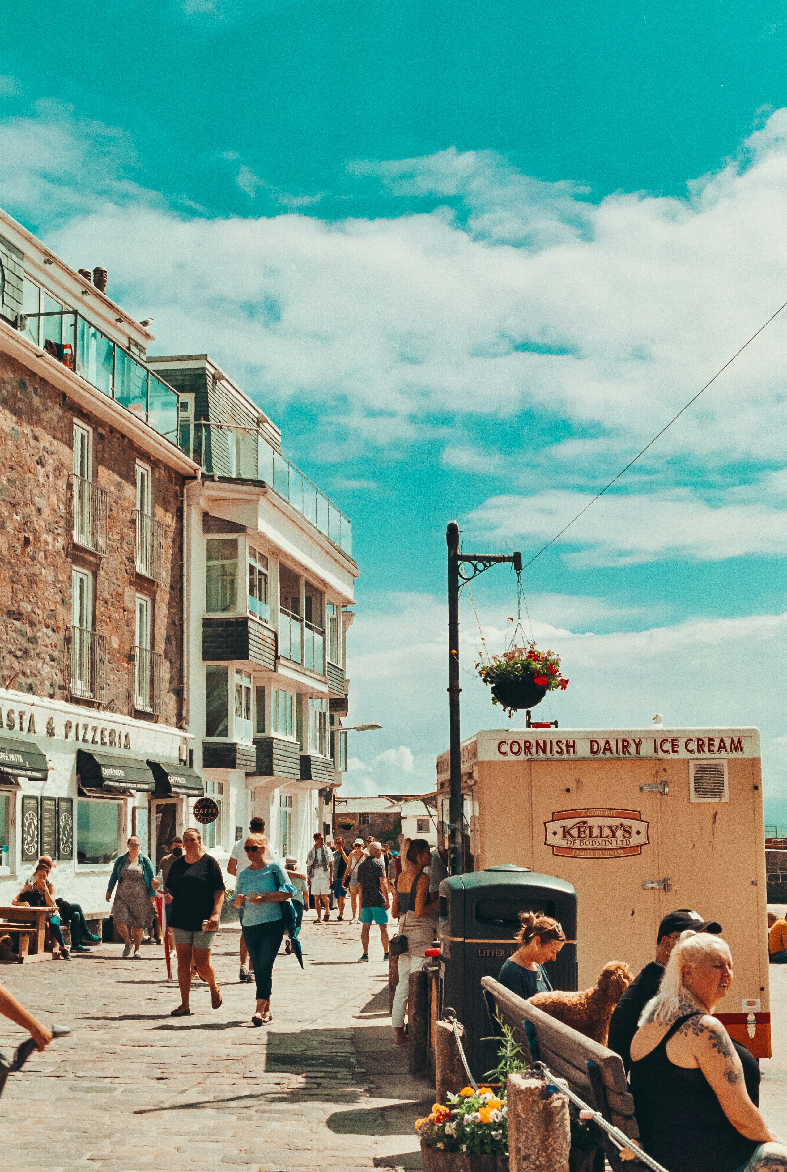 Un grupo de personas caminando por una calle junto a edificios altos