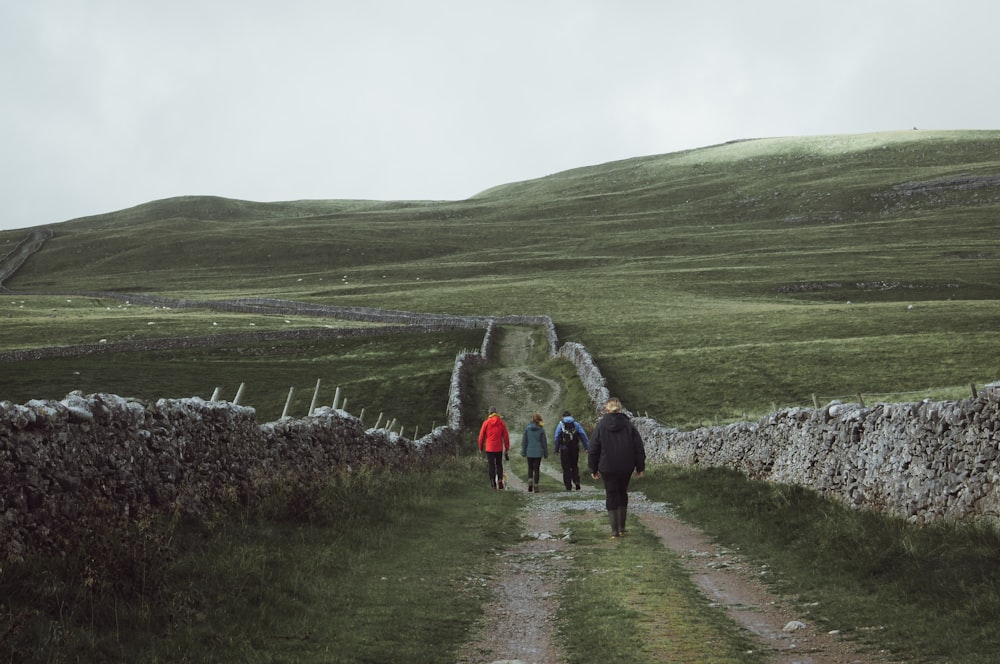 a group of people walking down a dirt road