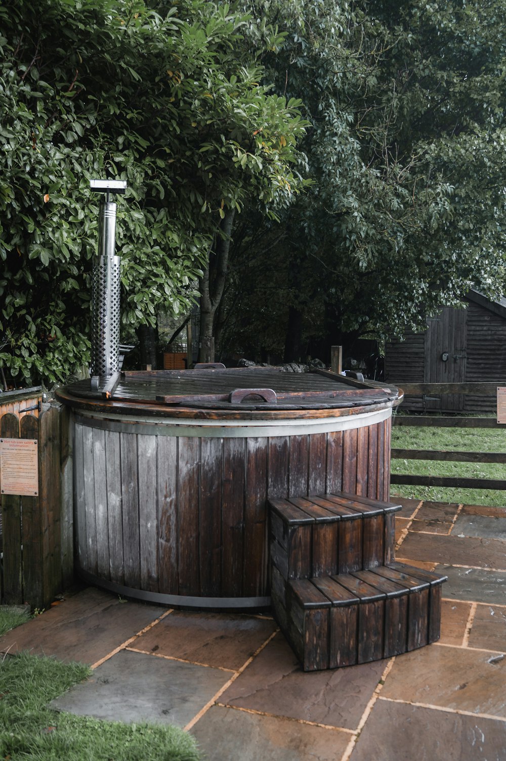 a wooden hot tub sitting on top of a lush green field