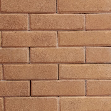 Photo of a brick wall under construction with workers laying bricks.
