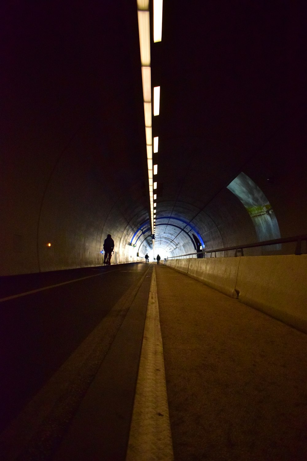 a man walking down a tunnel at night