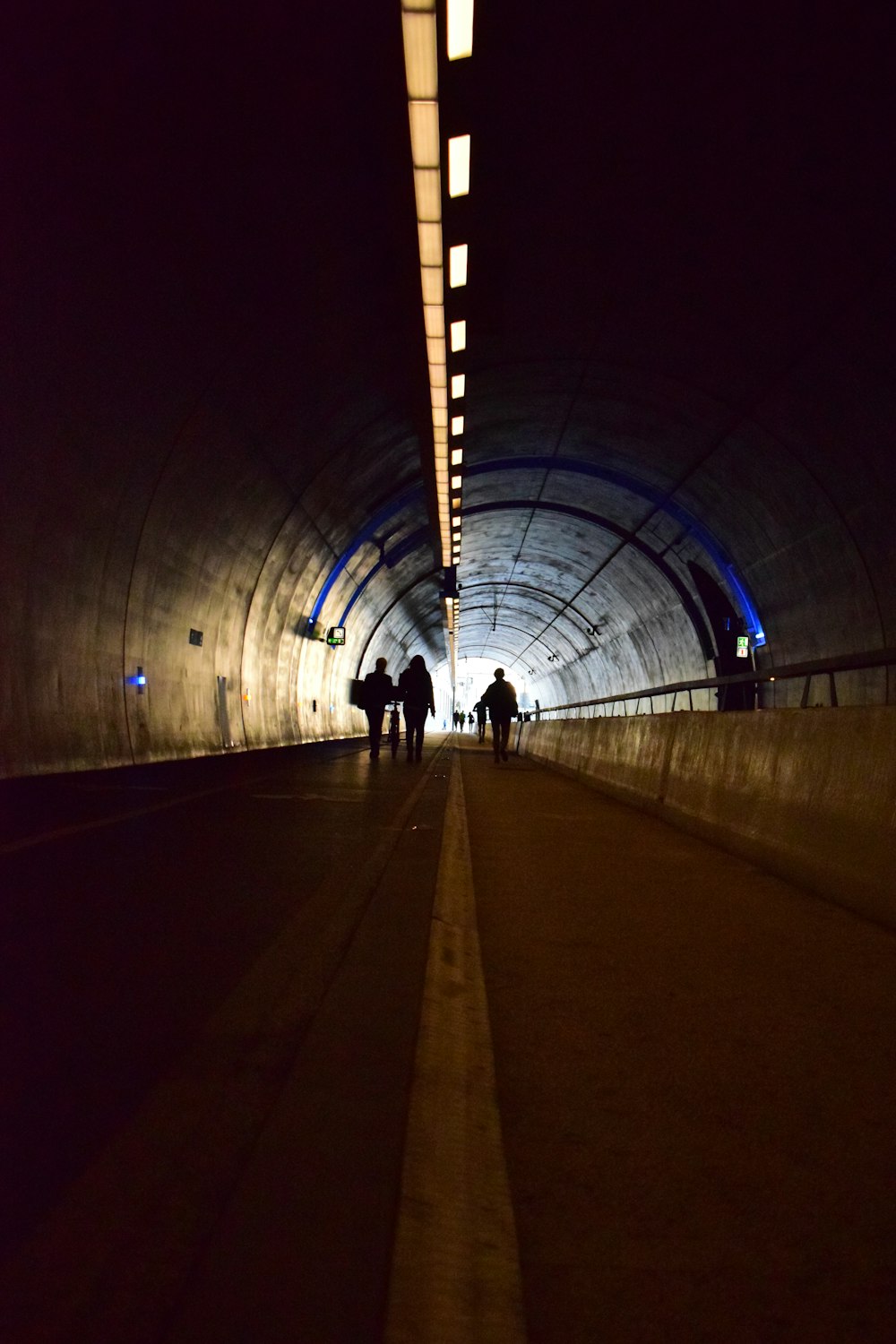 a group of people walking through a tunnel at night