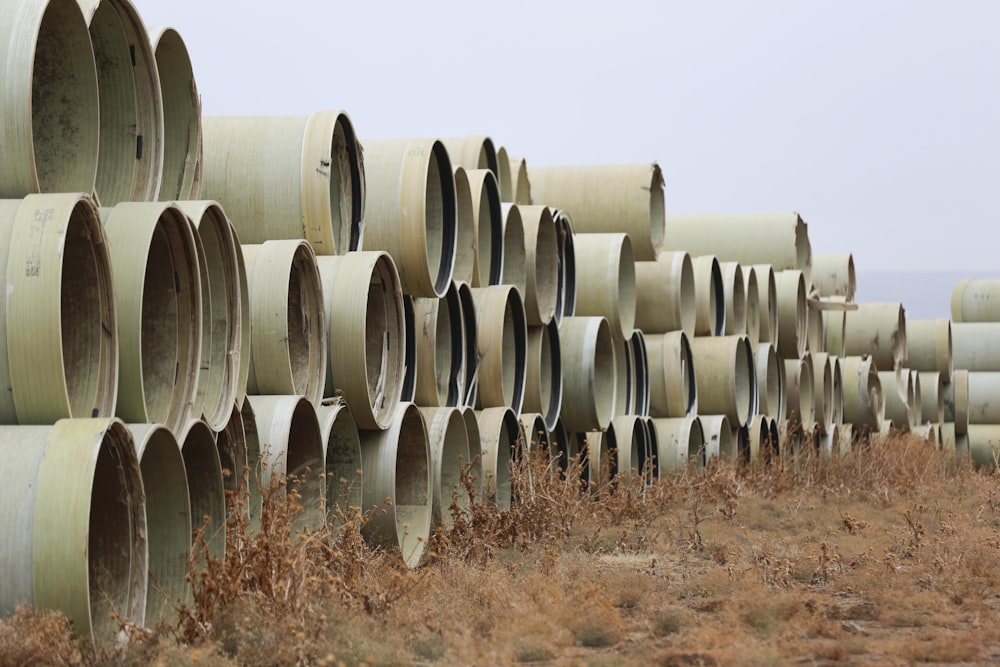 a large stack of pipes sitting in the middle of a field