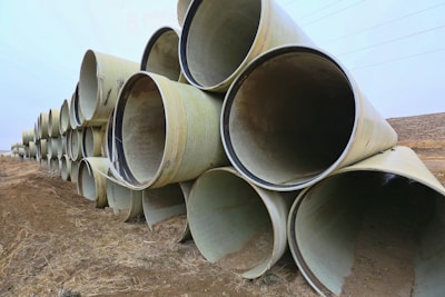 Close-up of durable irrigation pipes stacked outdoors on a sunny day.