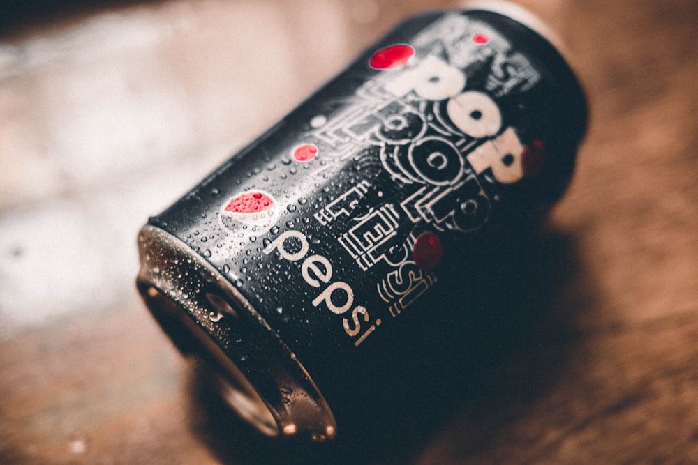 a can of soda sitting on top of a wooden table