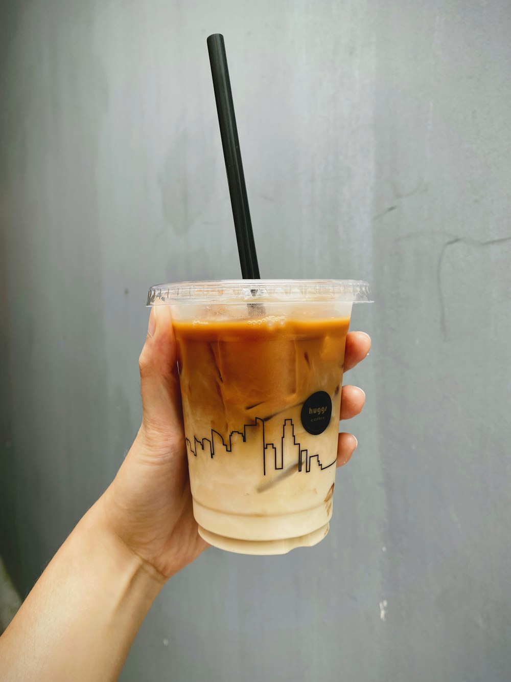 a hand holding a cup of iced coffee