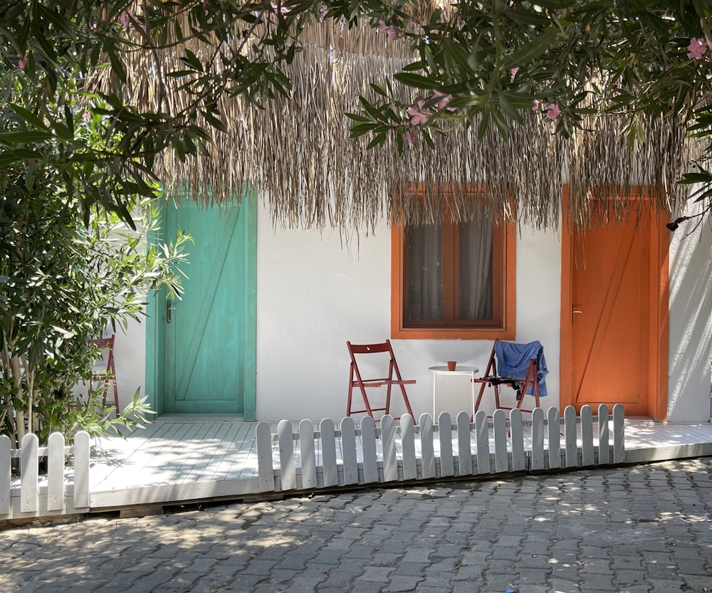 two chairs and a table in front of a house