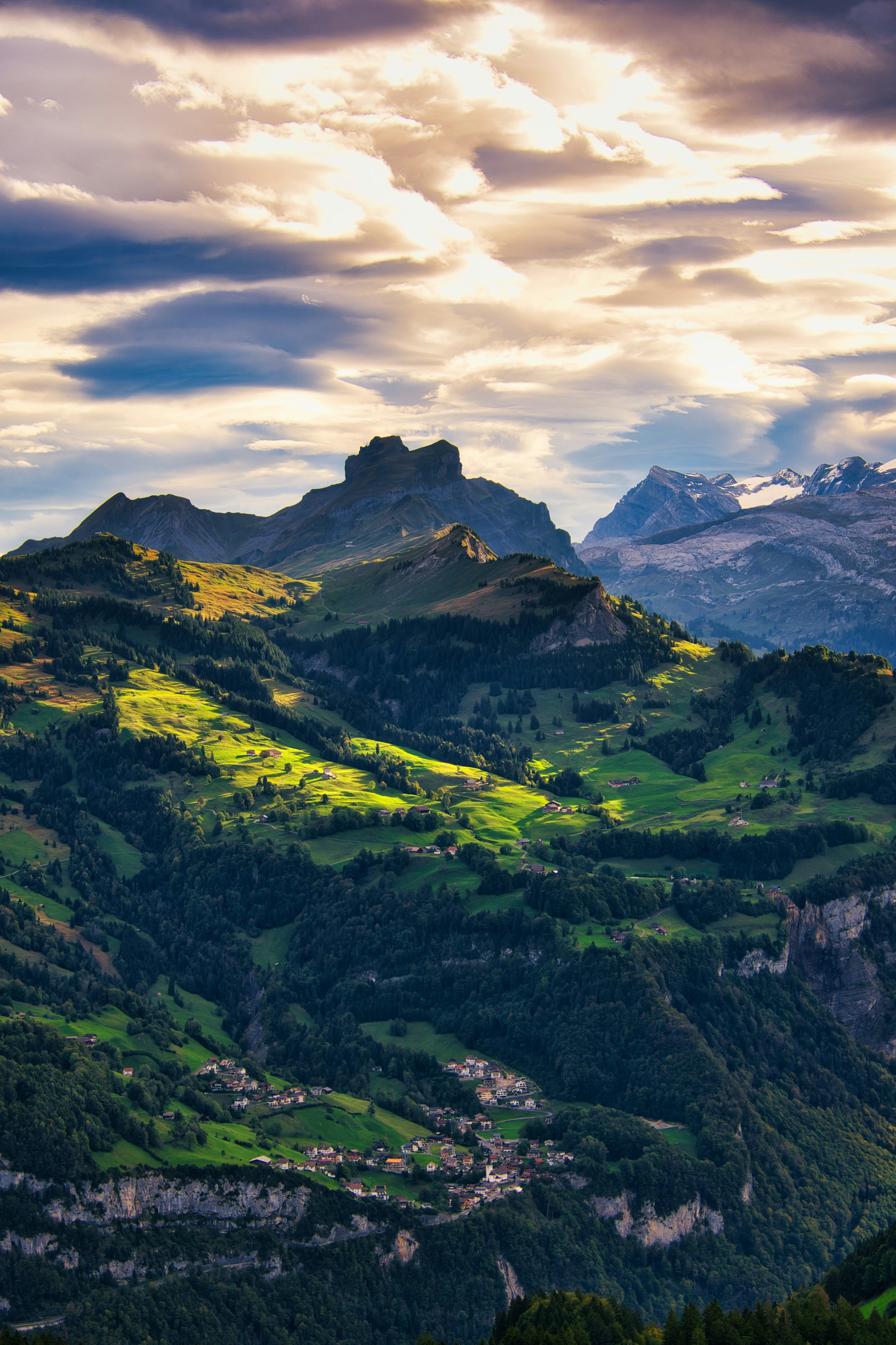 A view of a mountain range with green fields and mountains in the