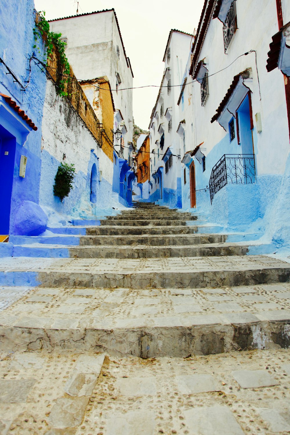 a set of stone steps leading up to a blue building