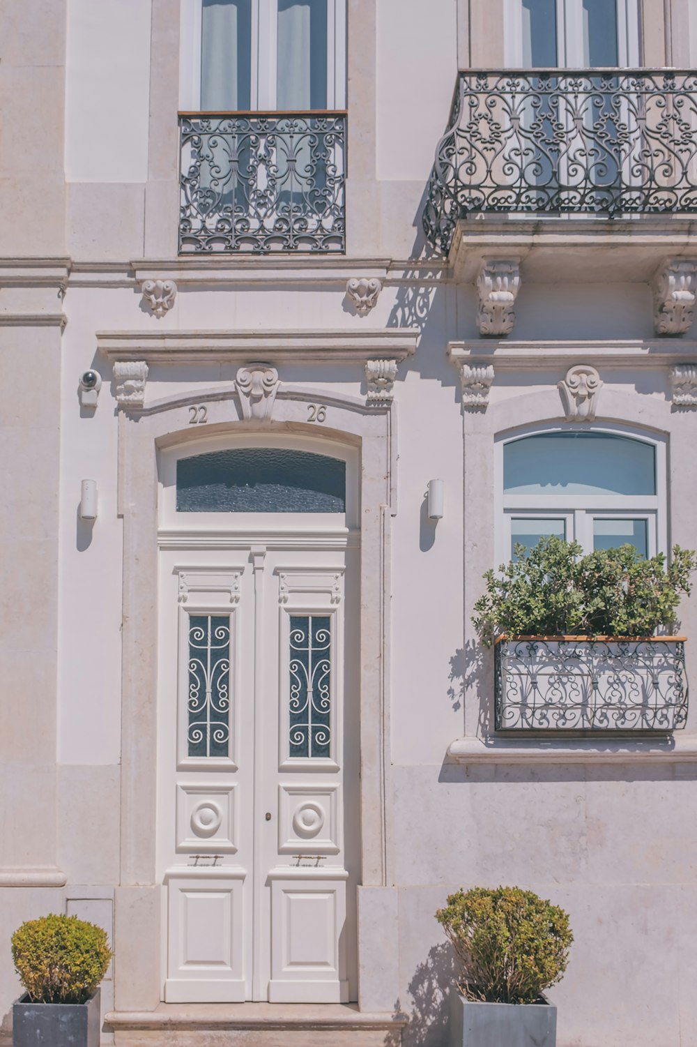 a white building with two planters on the front of it